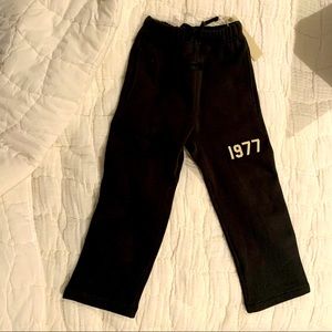 These are boys/girls Essentials Fear of God black sweatpants.